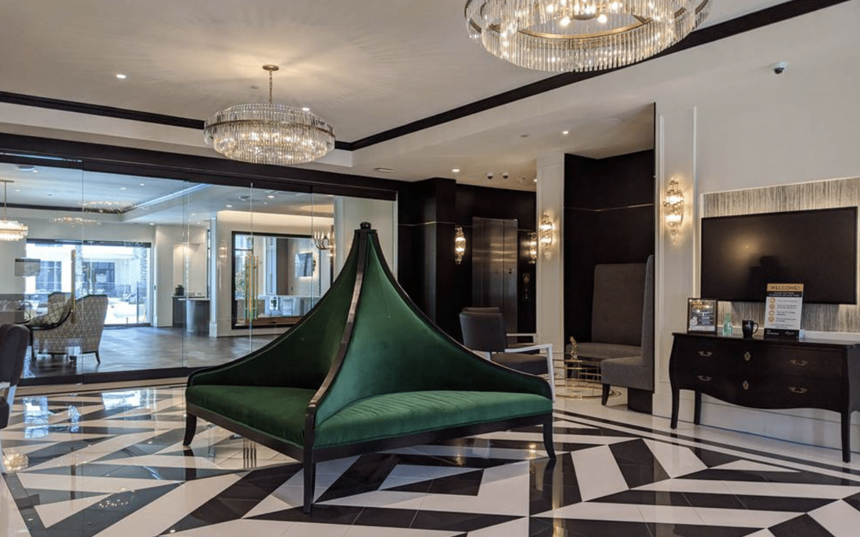Lobby with green sculptural bench and checkered flooring.